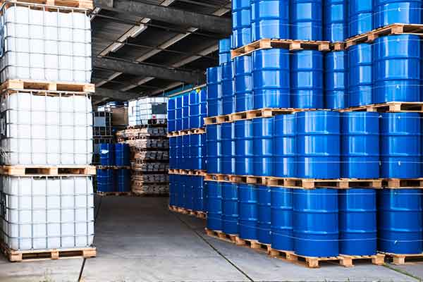 IBC containers and steel drums in an outdoor storage facility