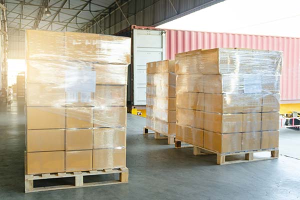 Stretch-wrapped pallets in front of container truck