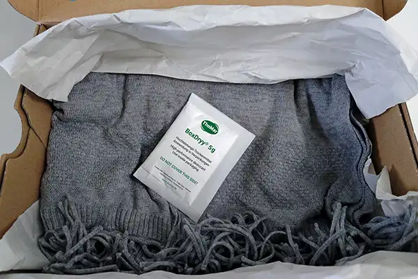 Le sachet déshydratant BoxDryy® protège les textiles dans un carton sans emballage en film